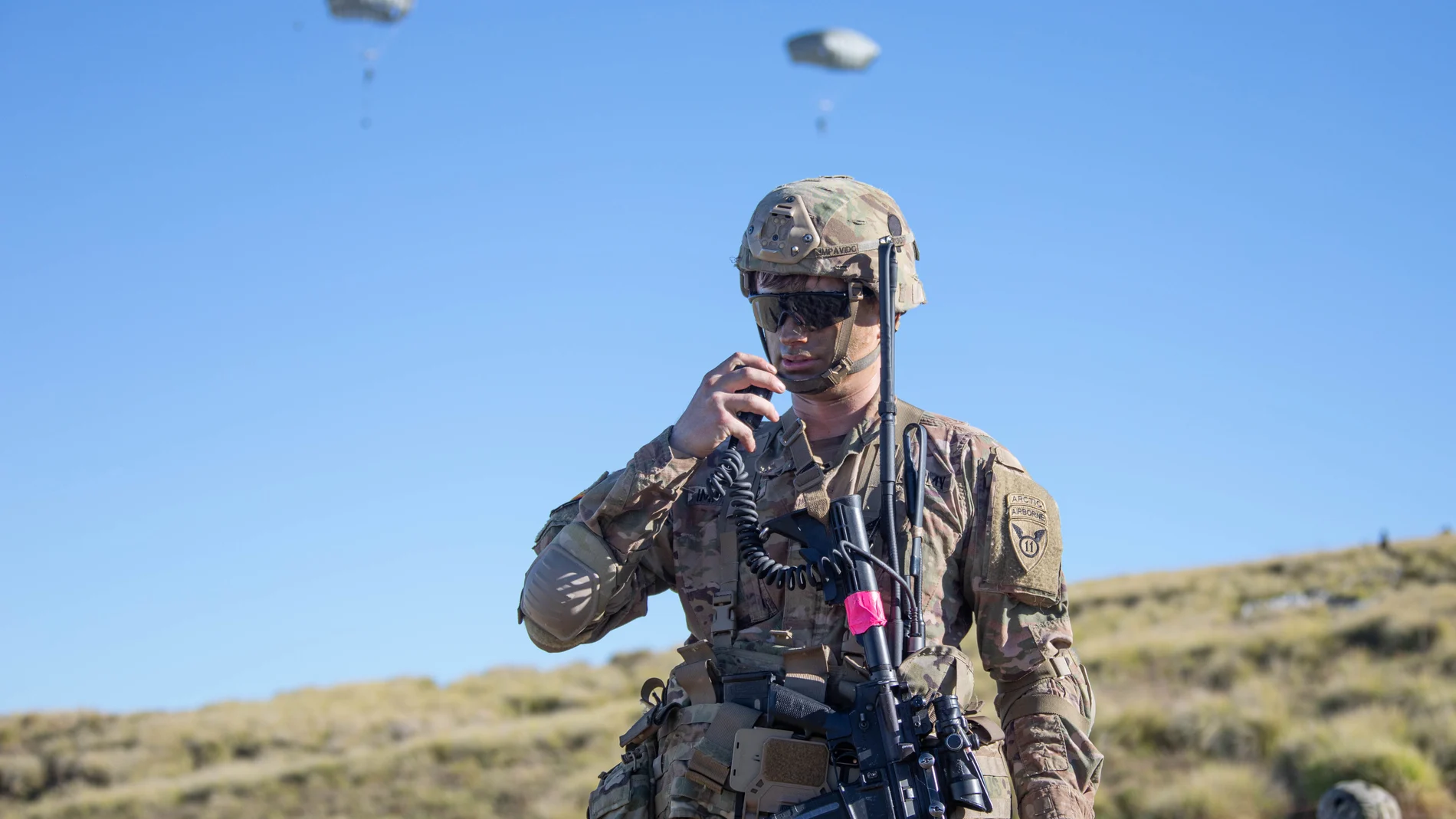 Soldado hablando por radio en unas maniobras y con uniforme de camuflaje