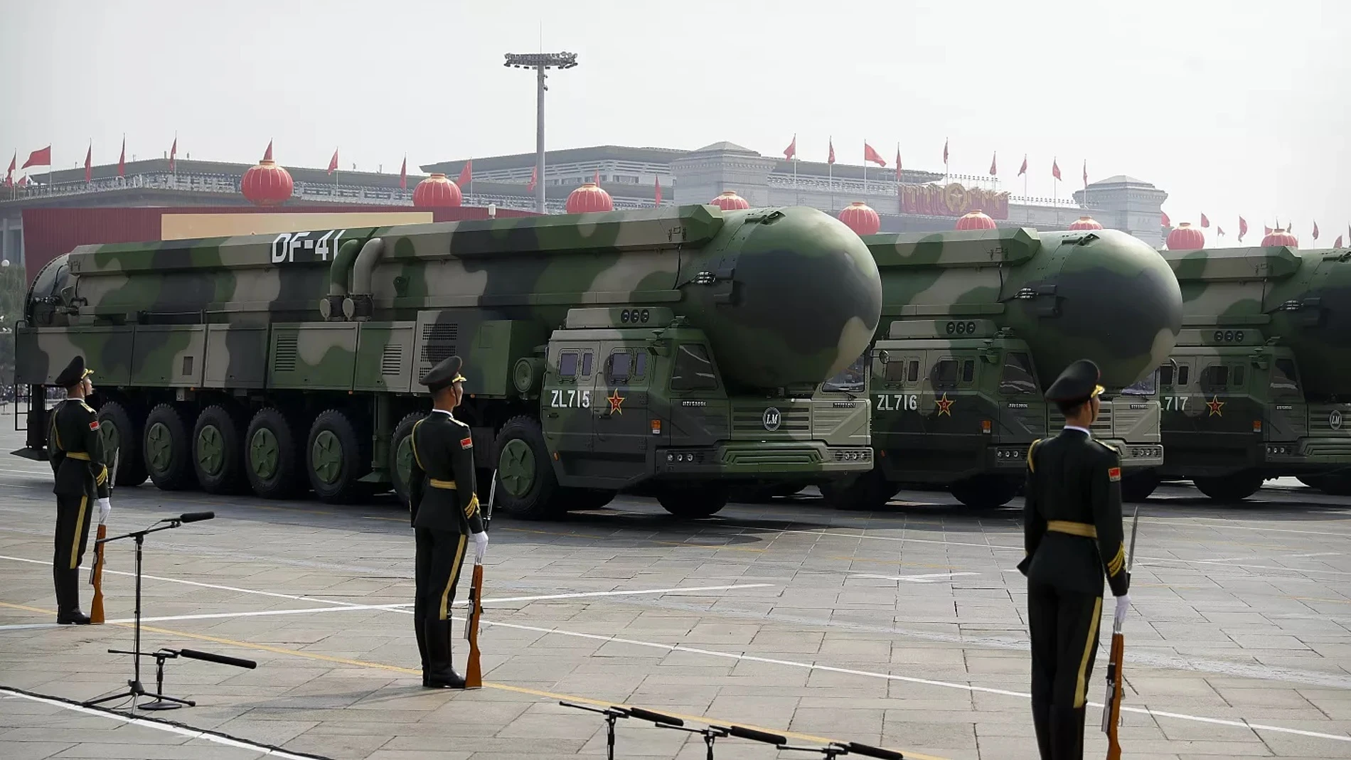 Aparece tres soldados en posición firmes delante de tres camiones que transportan sistemas nucleares