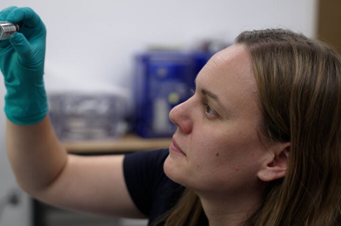 Jessica Barnes examina un vial que contiene partículas de muestra en el Laboratorio Kuiper-Arizona de Análisis de Astromateriales, ubicado en la Universidad de Arizona.