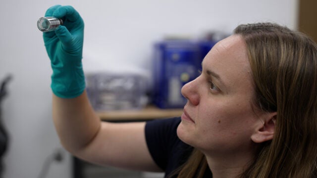 Jessica Barnes examina un vial que contiene partículas de muestra en el Laboratorio Kuiper-Arizona de Análisis de Astromateriales, ubicado en la Universidad de Arizona.