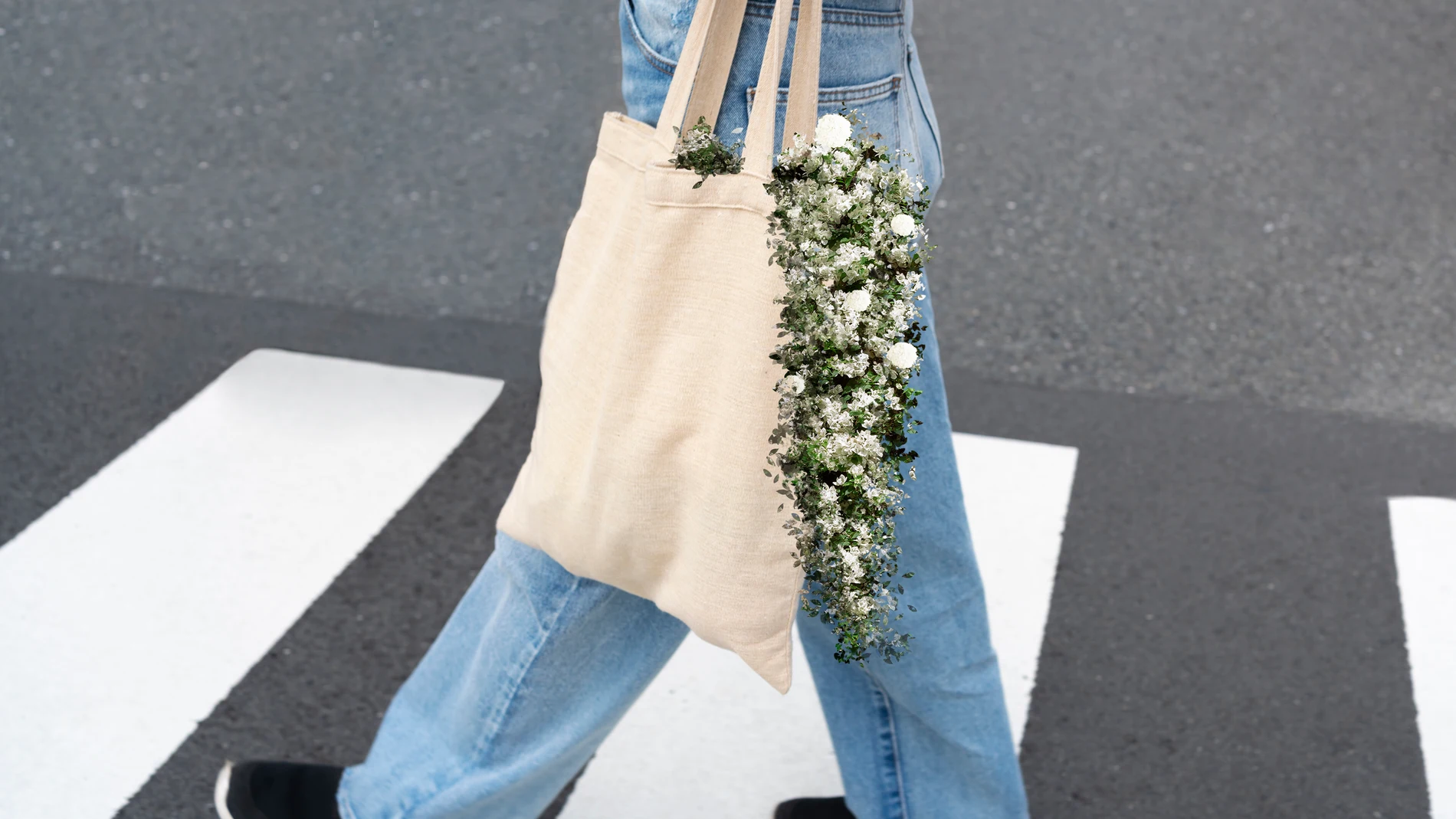 Mujer cruzando un paso de cebra llevando una tote bag