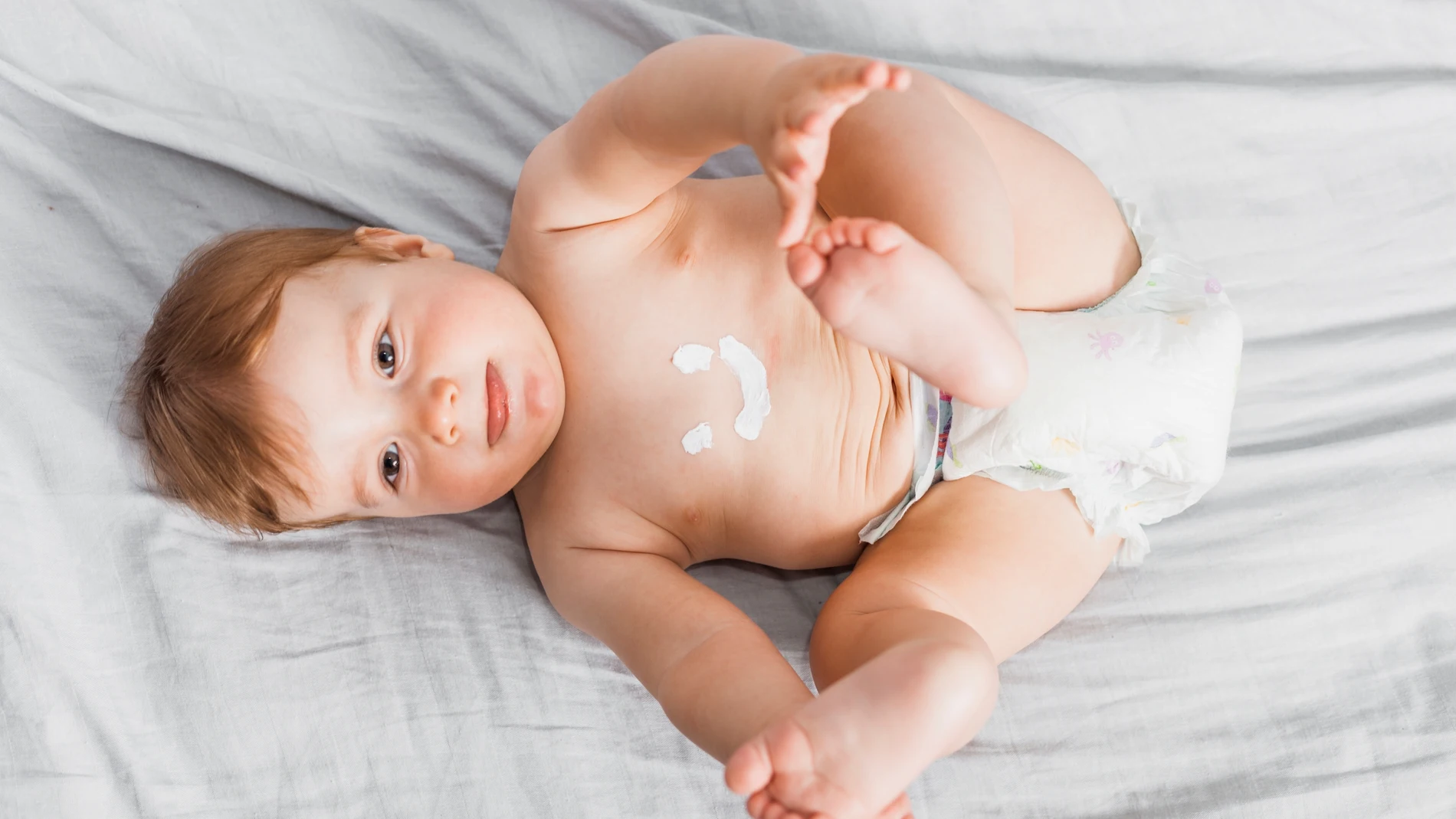 Bebé con crema en el cuerpo