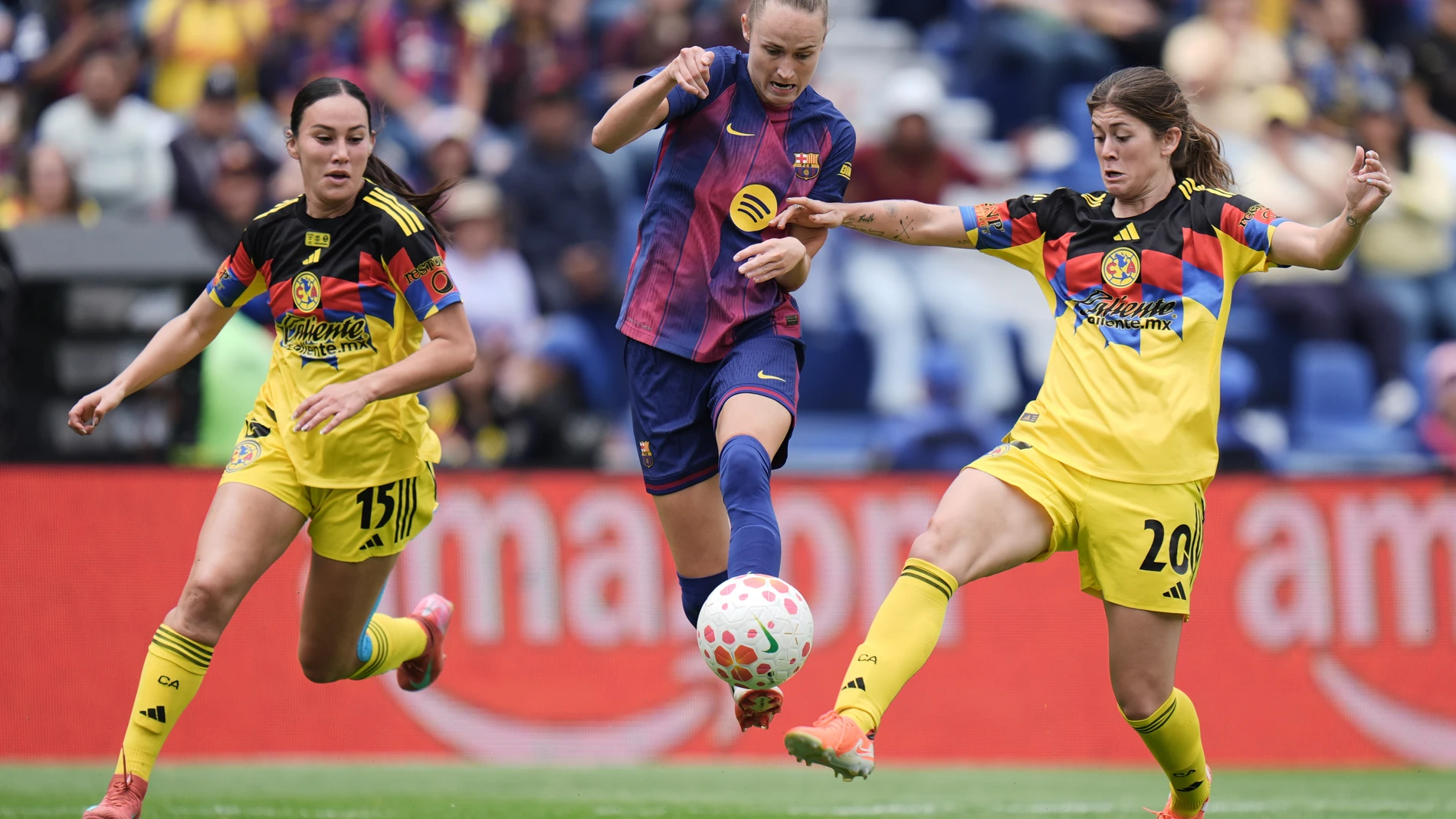 Barcelona's Caroline Graham, center, and America's Nicolette Hernandez, right, compete for the ball during a women's international friendly soccer match in Mexico City, Sunday, Aug. 24, 2025. (AP Photo/Eduardo Verdugo)