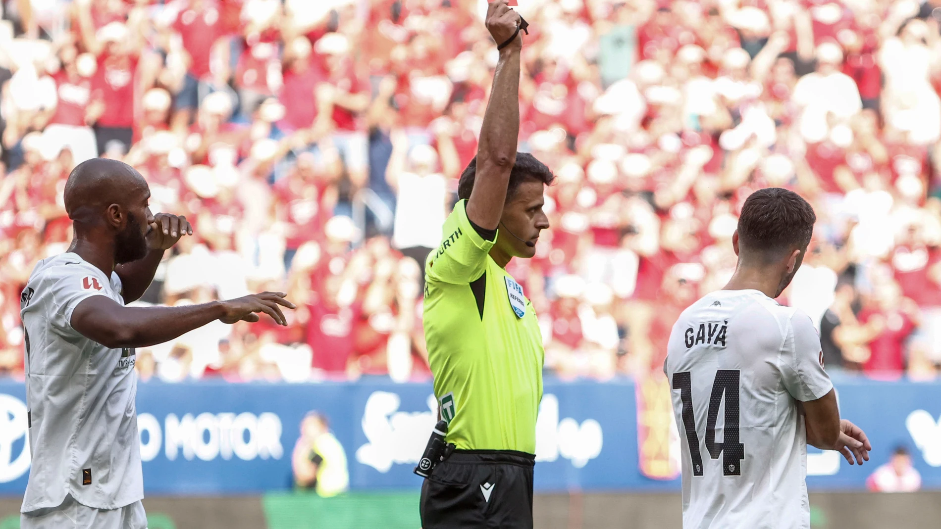 PAMPLONA, 24/08/2025.- El árbitro Gil Manzano (c) muestra la tarjeta roja a José Luis Gayá, del Valencia, durante el partido de LaLiga de fútbol que CA Osasuna y Valencia CF han disputado este domingo en el estadio de El Sadar, en Pamplona. EFE/Jesús Diges