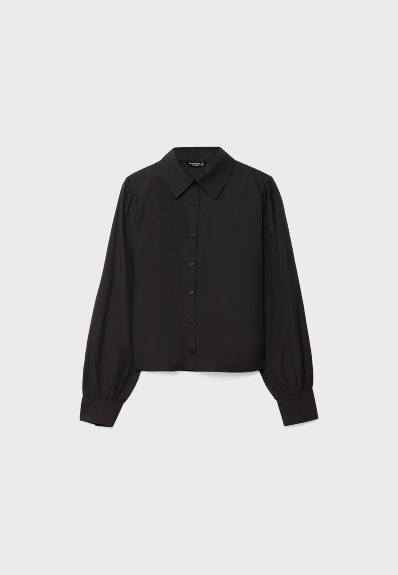 Camisa en negro con mangas abullonadas.