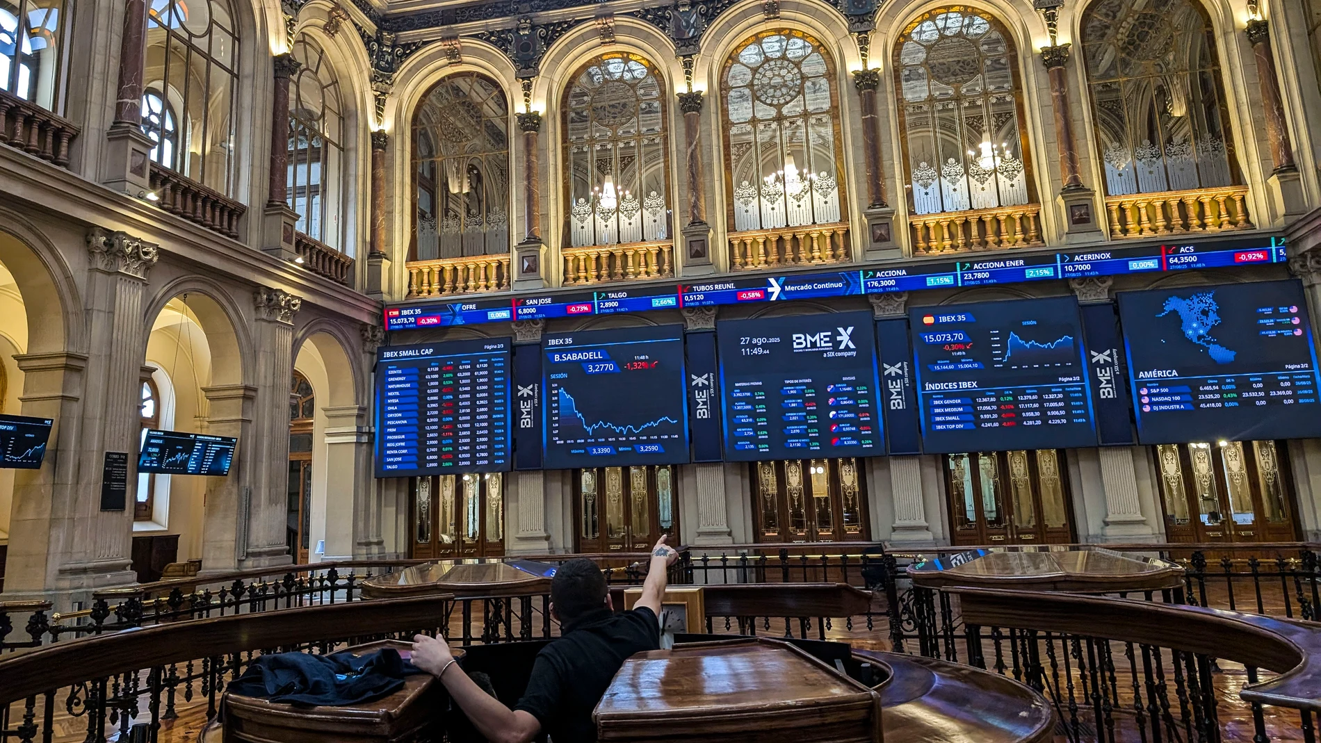 MADRID, 27/08/2025.- Varios paneles y monitores muestran en el parqué madrileño la evolución de la Bolsa española este miércoles en el que baja el 0,04 % después de la apertura y se acerca a 15.100 puntos afectada por el retroceso de la banca y a pesar de la subida de Wall Street el martes. EFE/ Vega Alonso