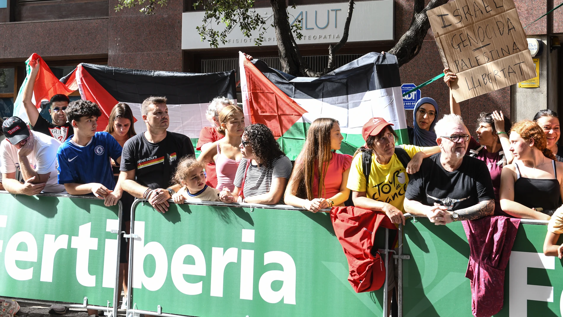 Varias personas sostienen banderas palestinas durante una concentración contra la participación del equipo ciclista Israel-Premier Tech en la Vuelta a España 2025, a 27 de agosto de 2025, en Figueres, Girona, Catalunya (España). Movimientos propalestinos españoles e italianos han organizado protestas a lo largo del recorrido contra el equipo ciclista Israel-Premier Tech, reclamando el boicot deportivo a Israel. El equipo, dirigido por Sylvan Adams, es visto como una herramienta de “sportwashi...